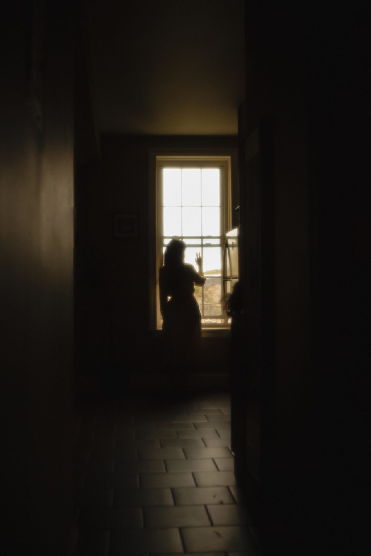Femme à une fenêtre en contre-jour